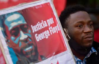 1217144506 BUENOS AIRES, ARGENTINA - JUNE 02: A protester holds a sign demanding justice for George Floyd during a demonstration on June 2, 2020 in Buenos Aires, Argentina. Protests spread across cities around the world in response to the death of African American George Floyd while in police custody in Minneapolis, Minnesota. (Photo by Gustavo Garello/Jam Media/Getty Images)