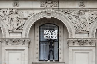 LONDON, ENGLAND - JUNE 03: A protester holds up a 'Black Lives Matter' sign as they stand on a windowsill of the Foreign and Commonwealth Office during the Black Lives Matter protest on Whitehall on June 3, 2020 in London, United Kingdom. The death of an African-American man, George Floyd, while in the custody of Minneapolis police has sparked protests across the United States, as well as demonstrations of solidarity in many countries around the world. (Photo by Dan Kitwood/Getty Images)
