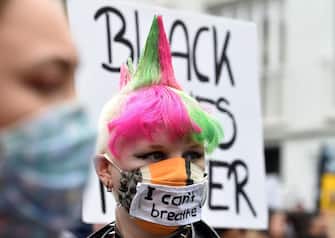 A protestor wears a face mask bearin ght eslogan "I can't breathe" during a demonstration in solidarity with protests raging across the US over his death on June 6, 2020 in Leipzig, eastern Germany. - The death during the arrest of George Floyd, an unarmed black man in the US state of Minnesota, has brought tens of thousands out onto the streets during a pandemic that is ebbing in Asia and Europe, but spreading in other parts of the world. (Photo by Christof STACHE / AFP)