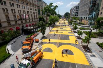 WASHINGTON, DC - JUNE 05: People walk down 16th street after volunteers, with permission from the city, painted "Black Lives Matter" on the street near the White House on June 05, 2020 in Washington, DC. After seven days of protests in DC over the death of George Floyd, DC Mayor Muriel Bowser has renamed that section of 16th street "Black Lives Matter Plaza". (Photo by Tasos Katopodis/Getty Images)