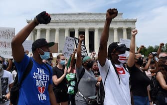 Demonstrator raise their fists at the Lincoln Memorial during a protest against police brutality and racism on June 6, 2020 in Washington, DC. - Demonstrations are being held across the US following the death of George Floyd on May 25, 2020, while being arrested in Minneapolis, Minnesota. (Photo by Olivier DOULIERY / AFP)