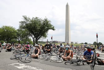 WASHINGTON, DC - JUNE 06: Bicyclist stop on Constitution Avenue to symbolically take a knee while protesting against police brutality and racism on June 6, 2020 in Washington, DC. This is the 12th day of protests with thousands of people descending on the city to peacefully demonstrate in the wake of the death of George Floyd, a black man who was killed in police custody in Minneapolis on May 25. (Photo by Win McNamee/Getty Images)
