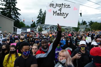 Family, friends and community members attend a vigil at the intersection where Manuel Ellis, a 33-year-old black man, died in Tacoma Police custody on March 3 and was recently ruled a homicide, according to the Pierce County Medical Examiners Office, in Tacoma, Washington on June 3, 2020. - US protesters welcomed new charges brought Wednesday against Minneapolis officers in the killing of African American man George Floyd -- but thousands still marched in cities across the country for a ninth straight night, chanting against racism and police brutality. (Photo by Jason Redmond / AFP) (Photo by JASON REDMOND/AFP via Getty Images)