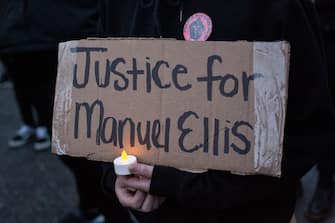 TACOMA, WA - JUNE 03: A person holds a sign during a vigil for Manuel Ellis, a black man whose March death while in Tacoma Police custody was recently found to be a homicide, according to the Pierce County Medical Examiners Office, near the site of his death on June 3, 2020 in Tacoma, Washington. Protests and other events sparked by the death of George Floyd have continued in the Tacoma area after the Medical Examiner found that the cause of death in the Manuel Ellis case was caused by respiratory arrest due to hypoxia due to physical restraint. (Photo by David Ryder/Getty Images)