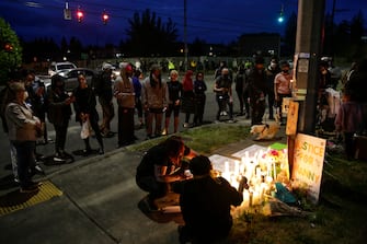 People gather and light candles at a makeshift memorial at the intersection where Manuel Ellis, a 33-year-old black man, died in Tacoma Police custody on March 3 and was recently ruled a homicide, according to the Pierce County Medical Examiners Office, in Tacoma, Washington on June 3, 2020. - US protesters welcomed new charges brought June 3 against Minneapolis officers in the killing of African American man George Floyd -- but thousands still marched in cities across the country for a ninth straight night, chanting against racism and police brutality. (Photo by Jason Redmond / AFP) (Photo by JASON REDMOND/AFP via Getty Images)