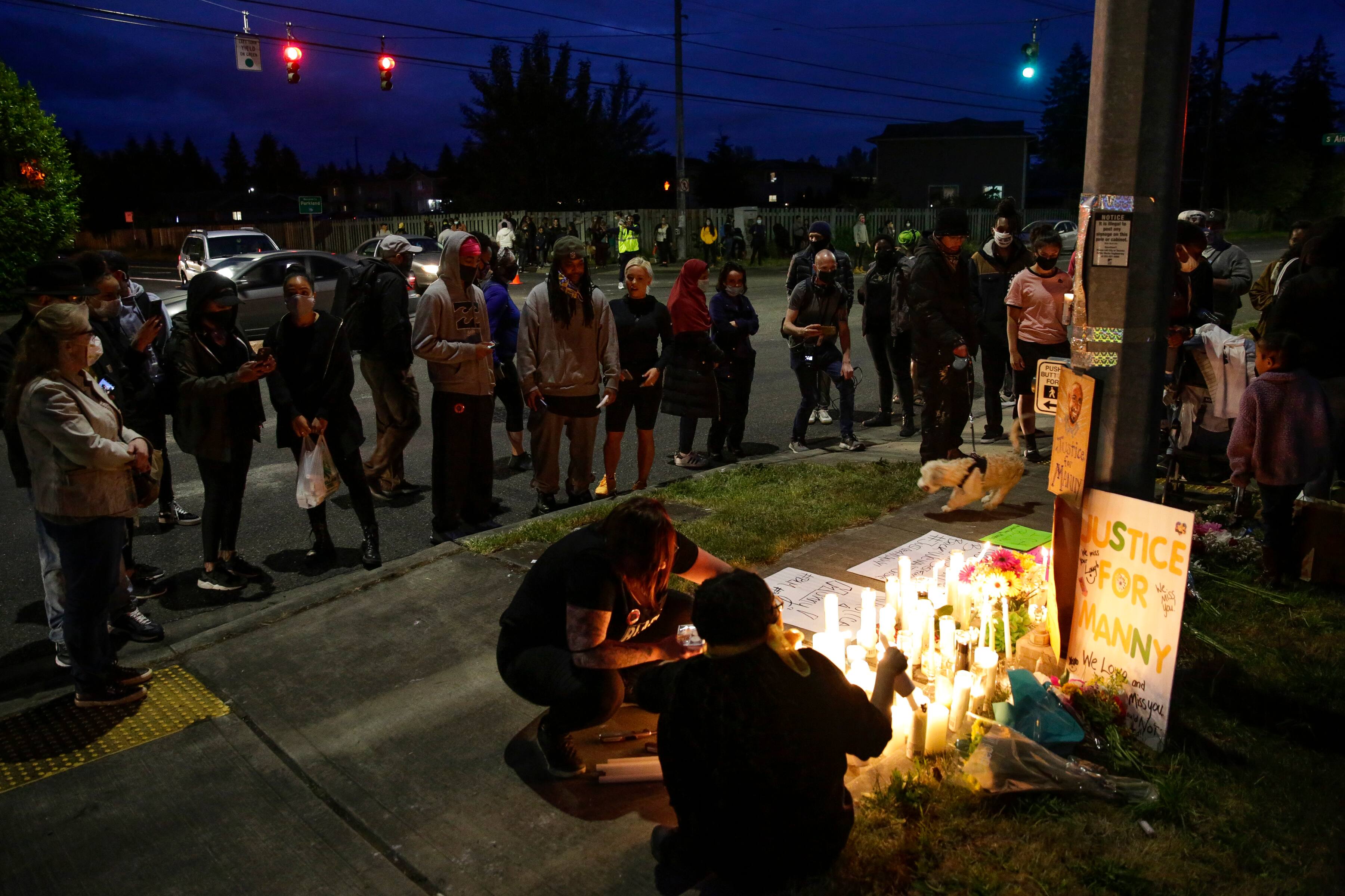 People gather and light candles at a makeshift memorial at the intersection where Manuel Ellis, a 33-year-old black man, died in Tacoma Police custody on March 3 and was recently ruled a homicide, according to the Pierce County Medical Examiners Office, in Tacoma, Washington on June 3, 2020. - US protesters welcomed new charges brought June 3 against Minneapolis officers in the killing of African American man George Floyd -- but thousands still marched in cities across the country for a ninth straight night, chanting against racism and police brutality. (Photo by Jason Redmond / AFP) (Photo by JASON REDMOND/AFP via Getty Images)