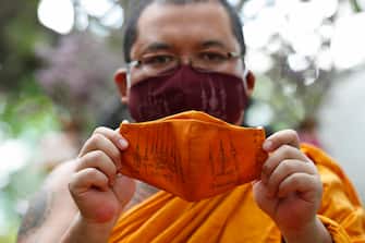 epa08470617 A Thai Buddhist monk displays a face mask made from recycled plastic bottles and inscribed with spiritual incantations aimed to protect devotees from the fear of the COVID-19 and coronavirus pandemic, at Wat Chak Daeng temple in Samut Prakan province, Thailand, 03 June 2020 (issued 07 June 2020). The Buddhist temple Wat Chak Daeng is well-known for managing the environmental campaign calling for donations of plastic bottles then transforming them into recycled fabrics before weaving and embroidering them into antibacterial robes. Amid the concerns of the ongoing spread of the COVID-19 disease, monks and volunteers produce facial mask made from used polyethylene terephthalate (PET) bottles collected by the temple's Buddhist monks, residents and donations aimed to control plastic waste as part of a waste management project to support environment protection and enhancing economic opportunities through recycled products. Thailand is one of the world's largest plastic polluters by generating more than two million tons of plastic waste each year.  EPA/RUNGROJ YONGRIT