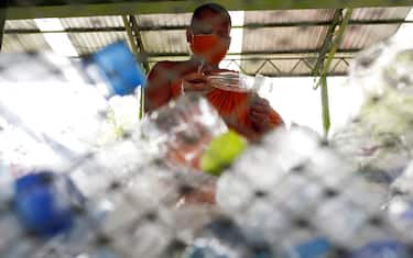 epa08470629 A Thai Buddhist monk sorts out recyclable plastic bottles to produce recycled facial masks and monk's saffron robes amid the ongoing spread of the COVID-19 and coronavirus pandemic, at Wat Chak Daeng temple in Samut Prakan province, Thailand, 03 June 2020 (issued 07 June 2020). The Buddhist temple Wat Chak Daeng is well-known for managing the environmental campaign calling for donations of plastic bottles then transforming them into recycled fabrics before weaving and embroidering them into antibacterial robes. Amid the concerns of the ongoing spread of the COVID-19 disease, monks and volunteers produce facial mask made from used polyethylene terephthalate (PET) bottles collected by the temple's Buddhist monks, residents and donations aimed to control plastic waste as part of a waste management project to support environment protection and enhancing economic opportunities through recycled products. Thailand is one of the world's largest plastic polluters by generating more than two million tons of plastic waste each year.  EPA/RUNGROJ YONGRIT