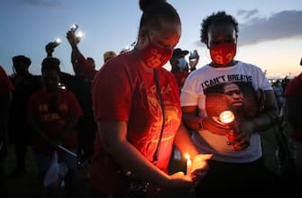 1248367011 HOUSTON, TEXAS - JUNE 08: School alumni and residents participate in a candlelight vigil honoring George Floyd on the football field of Jack Yates High School on June 8, 2020 in Houston, Texas. George Floyd, who played football for Yates High School, died on May 25th when he was in Minneapolis police custody, sparking nationwide protests. A white police officer, Derek Chauvin, has been charged with second-degree murder, with the three other officers involved facing other charges. (Photo by Mario Tama/Getty Images)