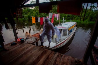 Health workers from the city of Melgaco arrive to a small riverside community at the Quara river, where eight families live without electricity, to give medical care to its residents amid concern over the spread of the COVID-19 coronavirus, in the southwest of Marajo Island, state of Para, Brazil, on June 9, 2020. (Photo by TARSO SARRAF / AFP) (Photo by TARSO SARRAF/AFP via Getty Images)