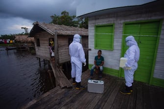 Health workers from the city of Melgaco check a resident of a small riverside community in the southwest of Marajo Island, state of Para, Brazil, on June 9, 2020, amid concern over the spread of the COVID-19 coronavirus. (Photo by TARSO SARRAF / AFP) (Photo by TARSO SARRAF/AFP via Getty Images)