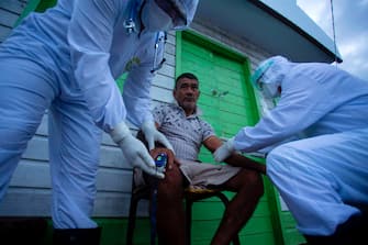 Health workers from the city of Melgaco check a resident of a small riverside community in the southwest of Marajo Island, state of Para, Brazil, on June 9, 2020, amid concern over the spread of the COVID-19 coronavirus. (Photo by TARSO SARRAF / AFP) (Photo by TARSO SARRAF/AFP via Getty Images)