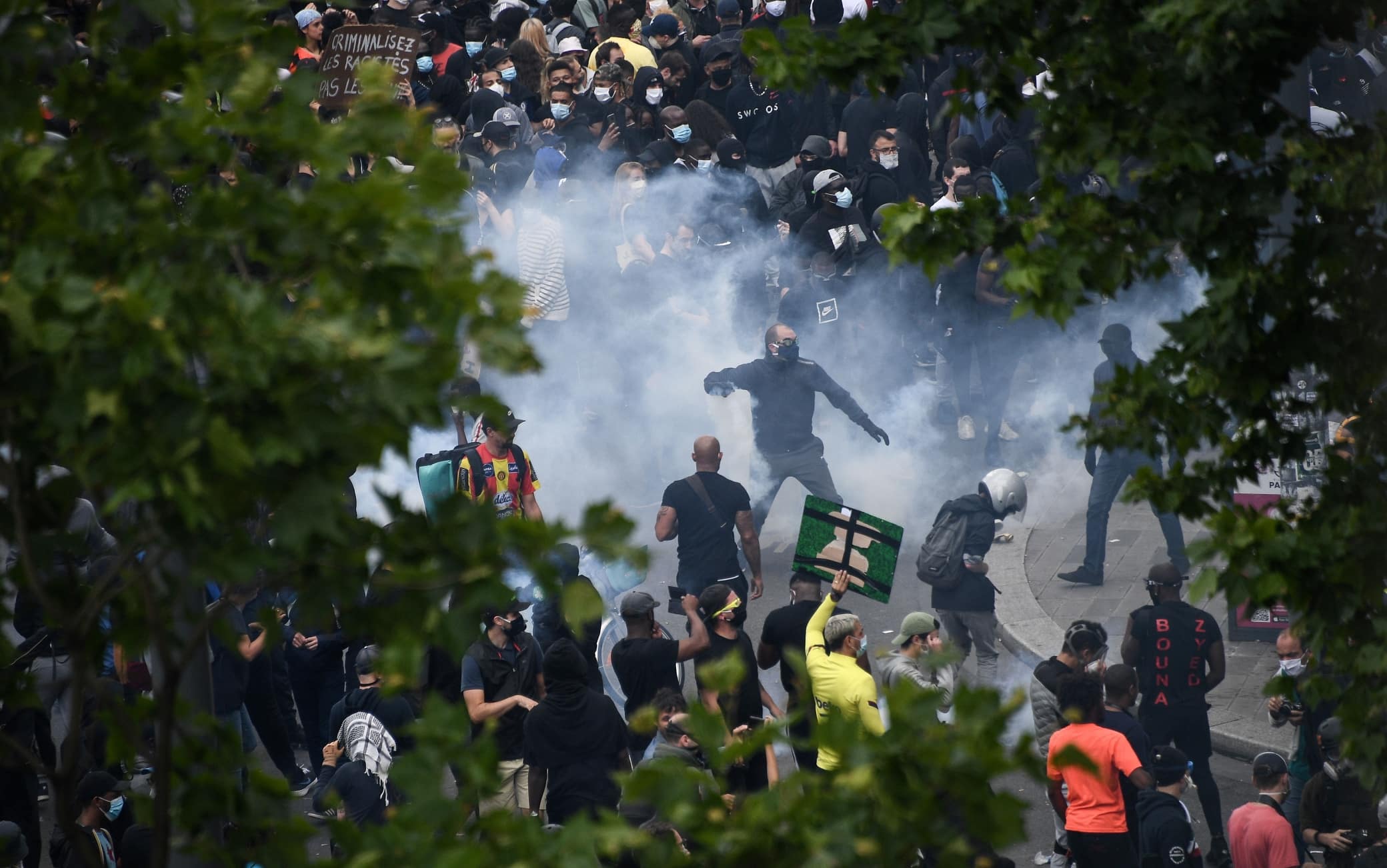 People throw back tear gas canisters at French riot police forces during a rally as part of the 'Black Lives Matter' worldwide protests against racism and police brutality, on Place de la Republique in Paris on June 13, 2020. - A wave of global protests in the wake of US George Floyd's fatal arrest magnified attention on the 2016 death in French police custody of Adama Traore, a 24-year-old black man, and renewed controversy over claims of racism and brutality within the force. (Photo by Anne-Christine POUJOULAT / AFP) (Photo by ANNE-CHRISTINE POUJOULAT/AFP via Getty Images)