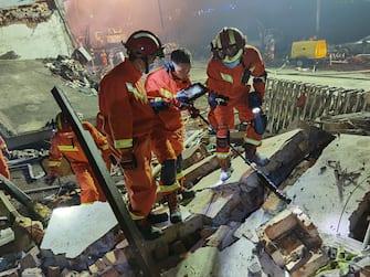 epa08484306 Rescuers work on a damaged building in the aftermath of an oil tanker truck s explosion in Wenling, Zhejiang province, China, 14 June 2020. An LNG truck exploded after going off the road on the nearby expressway on 13 June afternoon. The blast hurtled a portion of the truck into a nearby village. At least 19 people were killed and over 170 people were hospitalized.  EPA/XIAO FAN CHINA OUT