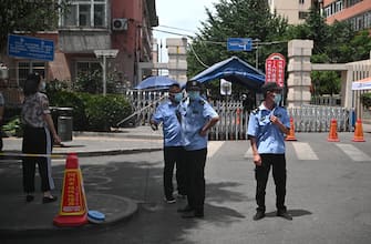 Security personnel wearing face masks stand in front of a residential area under lockdown near Yuquan East Market in Beijing on June 15, 2020. - China locks down ten more Beijing neighbourhoods over virus cluster. (Photo by Noel Celis / AFP) (Photo by NOEL CELIS/AFP via Getty Images)