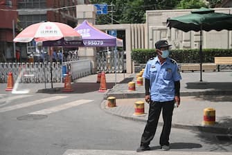 A security personnel wearing a face mask stands guard at a residential area under lockdown near Yuquan East Market in Beijing on June 15, 2020. - China locks down ten more Beijing neighbourhoods over virus cluster. (Photo by Noel Celis / AFP) (Photo by NOEL CELIS/AFP via Getty Images)