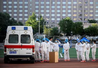 Medical personnel wearing protective suits gather at the Guang'an Sport Center before a swab test for people who visited or live near Xinfadi Market in Beijing on June 14, 2020. - The domestic COVID-19 coronavirus outbreak in China had been brought largely under control through strict lockdowns that were imposed early this year -- but a new cluster has been linked to Xinfadi market in south Beijing. (Photo by NOEL CELIS / AFP) (Photo by NOEL CELIS/AFP via Getty Images)