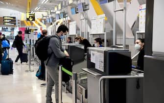A passenger wearing a face mask checks-in at Terminal 4 of the Madrid-Barajas Adolfo Suarez Airport in Barajas on April 7, 2020. - Spain's daily coronavirus death rate shot up to 743 after falling for four straight days, lifting the total toll to 13,798, the health ministry said. The number of new infections in the world's second hardest-hit country after Italy also grew at a faster pace, rising 4.1 percent to 140,510, it added. (Photo by JAVIER SORIANO / AFP) (Photo by JAVIER SORIANO/AFP via Getty Images)