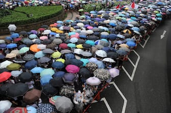 Protesters use umbrellas at it rains during a pro-democracy rally seeking greater democracy in Hong Kong on July 1, 2014 as frustration grows over the influence of Beijing on the city. July 1 is traditionally a day of protest in Hong Kong and also marks the anniversary of the handover from Britain to China in 1997, under a "one country, two systems" agreement. AFP PHOTO / DALE DE LA REY        (Photo credit should read DALE de la REY/AFP via Getty Images)
