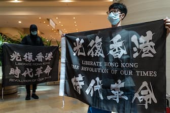 1219442940 HONG KONG, CHINA - JUNE 12: Pro-democracy supporters hold banners and shout slogans as they march in a shopping mall during a lunch protest on June 12, 2020 in Hong Kong, China. (Photo by Anthony Kwan/Getty Images)