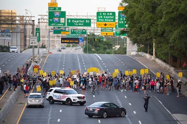 epa08487495 Protesters shut down Interstate 395, a highway that runs through the nation's capital, during a protest to demand justice for George Floyd and for racial equality, in Washington, DC, USA, 15 June 2020. Protesters kneeled on the ground and forced traffic to stop. The death of George Floyd while in police custody in Minneapolis has sparked global protests demanding policing reform.  EPA/MICHAEL REYNOLDS