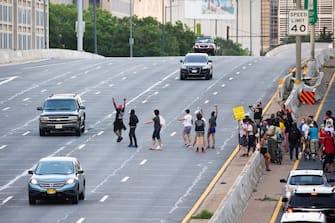 epa08487498 Protesters shut down Interstate 395, a highway that runs through the nation's capital, during a protest to demand justice for George Floyd and for racial equality, in Washington, DC, USA, 15 June 2020. Protesters kneeled on the ground and forced traffic to stop. The death of George Floyd while in police custody in Minneapolis has sparked global protests demanding policing reform.  EPA/MICHAEL REYNOLDS