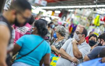 RIO DE JANEIRO, BRAZIL - JUNE 17: Shoppers wearing face masks walk in a crowded Mercadao de Madureira, at the Madureira neighborhood amidst the coronavirus (COVID-19) pandemic on June 17, 2020 in Rio de Janeiro, Brazil. Mercadao de Madureira is one of the most popular trading centers in Rio de Janeiro. The city of Rio de Janeiro started today the second phase of the quarantine flexibilization. The decree determines the return of 100% of the bus fleet and some commercial establishments following distance rules such as reduced opening hours, restricting the flow of people and maintaining hygiene standards. (Photo by Andre Coelho/Getty Images)