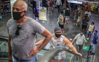RIO DE JANEIRO, BRAZIL - JUNE 17: Shoppers wearing face masks ride the escalator keeping social distance in Mercadao de Madureira, at the Madureira neighborhood amidst the coronavirus (COVID-19) pandemic on June 17, 2020 in Rio de Janeiro, Brazil. Mercadao de Madureira is one of the most popular trading centers in Rio de Janeiro. The city of Rio de Janeiro started today the second phase of the quarantine flexibilization. The decree determines the return of 100% of the bus fleet and some commercial establishments following distance rules such as reduced opening hours, restricting the flow of people and maintaining hygiene standards. (Photo by Andre Coelho/Getty Images)