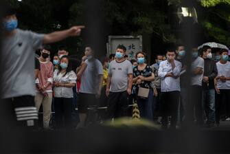 BEIJING, CHINA - JUNE 18: People who have had contact with the Xinfadi Wholesale Market or someone who could have visited the area, line up to receive a nucleic acid test for COVID-19  at a testing center on June 18, 2020 in Beijing, China. Authorities are trying to contain the outbreak linked to the Xinfadi wholesale food market, Beijing's biggest supplier of produce and meat. Several neighborhoods have been locked down and at least two other food markets were closed, as tens of thousands of people are being tested for COVID-19 at sites set up around the city. The outbreak has triggered fears of a second wave of infection after 56 straight days with no domestically transmitted cases in the capital. More than 8,000 vendors and staff at Xinfadi have already been tested, according to city officials, who are using contact tracing to reach an estimated 200,000 people who have visited the market since May 30. (Photo by Kevin Frayer/Getty Images)
