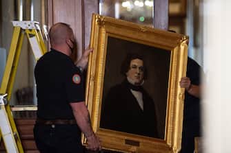 Architect of the Capitol maintenance workers remove a painting of former confederate House Speaker Howell Cobb of Georgia, from the east staircase of the Speakers lobby, on Capitol Hill on June 18, 2020. - House Speaker Nancy Pelosi on June 18 ordered the removal from the US Capitol of four portraits of former lawmakers who served in the Confederacy, saying their images symbolize "grotesque racism."  The four outgoing portraits depict 19th century speakers of the House who also served in the Confederacy: Robert Hunter of Virginia, Howell Cobb of Georgia, James Orr of South Carolina, and Charles Crisp of Georgia. (Photo by Nicholas Kamm / POOL / AFP) (Photo by NICHOLAS KAMM/POOL/AFP via Getty Images)