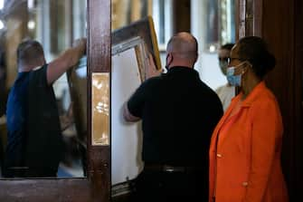 House Clerk Cheryl Johnson (R) looks on as Architect of the Capitol maintenance workers remove a painting of Howell Cobb of Georgia from the Speaker's Lobby of the US Capitol during the removal of two portraits of Confederate speakers of the House, James Orr and Howell Cobbs, in Washington, DC, on June 18, 2020. - House Speaker Nancy Pelosi on June 18 ordered the removal from the US Capitol of four portraits of former lawmakers who served in the Confederacy, saying their images symbolize "grotesque racism."  The four outgoing portraits depict 19th century speakers of the House who also served in the Confederacy: Robert Hunter of Virginia, Howell Cobb of Georgia, James Orr of South Carolina, and Charles Crisp of Georgia. (Photo by Graeme Jennings / POOL / AFP) (Photo by GRAEME JENNINGS/POOL/AFP via Getty Images)