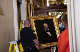 House Clerk Cheryl Johnson looks on as Architect of the Capitol maintenance workers remove a painting of former confederate speaker James Orr of South Carolina, from the east staircase of the Speakers lobby, on Capitol Hill on June 18, 2020. - House Speaker Nancy Pelosi on June 18 ordered the removal from the US Capitol of four portraits of former lawmakers who served in the Confederacy, saying their images symbolize "grotesque racism."  The four outgoing portraits depict 19th century speakers of the House who also served in the Confederacy: Robert Hunter of Virginia, Howell Cobb of Georgia, James Orr of South Carolina, and Charles Crisp of Georgia. (Photo by Nicholas Kamm / POOL / AFP) (Photo by NICHOLAS KAMM/POOL/AFP via Getty Images)