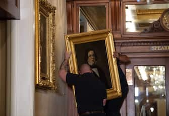 Architect of the Capitol maintenance workers remove a painting of former confederate House Speaker Howell Cobb of Georgia, from the east staircase of the Speakers lobby, on Capitol Hill on June 18, 2020. - House Speaker Nancy Pelosi on June 18 ordered the removal from the US Capitol of four portraits of former lawmakers who served in the Confederacy, saying their images symbolize "grotesque racism."  The four outgoing portraits depict 19th century speakers of the House who also served in the Confederacy: Robert Hunter of Virginia, Howell Cobb of Georgia, James Orr of South Carolina, and Charles Crisp of Georgia. (Photo by Nicholas Kamm / POOL / AFP) (Photo by NICHOLAS KAMM/POOL/AFP via Getty Images)