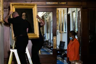 House Clerk Cheryl Johnson (R) looks on as Architect of the Capitol maintenance workers remove a painting of Howell Cobb of Georgia from the Speaker's Lobby of the US Capitol during the removal of two portraits of Confederate speakers of the House, James Orr and Howell Cobbs, in Washington, DC, on June 18, 2020. - House Speaker Nancy Pelosi on June 18 ordered the removal from the US Capitol of four portraits of former lawmakers who served in the Confederacy, saying their images symbolize "grotesque racism."  The four outgoing portraits depict 19th century speakers of the House who also served in the Confederacy: Robert Hunter of Virginia, Howell Cobb of Georgia, James Orr of South Carolina, and Charles Crisp of Georgia. (Photo by Graeme Jennings / POOL / AFP) (Photo by GRAEME JENNINGS/POOL/AFP via Getty Images)