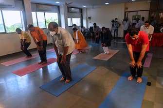 1221540704 Men attend a yoga class during International Yoga Day, in Mumbai on June 21, 2020. (Photo by INDRANIL MUKHERJEE / AFP) (Photo by INDRANIL MUKHERJEE/AFP via Getty Images)
