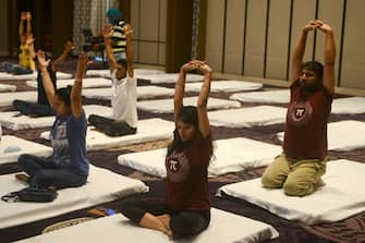 People attend a yoga class at a hotel during International Yoga Day, in Siliguri on June 21, 2020. (Photo by Diptendu DUTTA / AFP) (Photo by DIPTENDU DUTTA/AFP via Getty Images)