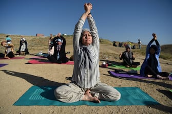 Fakhria Momtaz (C), 43, a yoga teacher and founder of Kabul's first yoga center for women, takes part in a yoga session at Shahrak Haji Nabi hilltop during International Yoga Day, on the outskirts of Kabul on June 21, 2020. (Photo by WAKIL KOHSAR / AFP) (Photo by WAKIL KOHSAR/AFP via Getty Images)