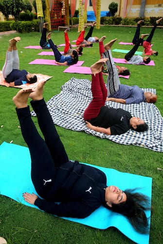 epa08499681 Indian women performing yoga on World Yoga Day, in Bhopal, India, 21 June 2020. The United Nations proclaimed 21 June as the International Day of Yoga, by its resolution 69/131 on 11 December 2014.  EPA/SANJEEV GUPTA