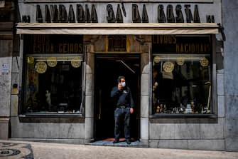 A man speaks on the phone in front of his bookshop in Lisbon on May 4, 2020 as millions of Europeans emerged with relief from coronavirus confinement. - Portugal allowed small shops, hair salons and car dealers to resume business, but ordered face masks to be worn in stores and on public transport. (Photo by PATRICIA DE MELO MOREIRA / AFP) (Photo by PATRICIA DE MELO MOREIRA/AFP via Getty Images)