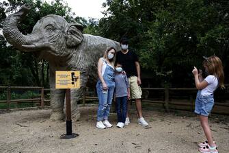 epa08501307 A family wearing a mask takes a photo with a statue of a elephant at the Cali Zoo, Colombia, 21 June 2020. On 21 June and after being closed for more than three months, the Cali Zoo is the first in Latin America to open its doors to the public again in the midst of the COVID-19 pandemic and under the strictest biosecurity measures.  EPA/Pablo Rodriguez