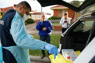 epa08507691 Paramedics perform COVID-19 disease tests in Broadmeadows after Victoria State Government Health and Human Services officials knock on doors to check if people have any symptoms of and would like a test, in Melbourne, Australia, 25 June 2020. The Australian Defence Force (ADF) and other states have been called in to help Victoria tackle its rising number of coronavirus cases.  EPA/DANIEL POCKETT AUSTRALIA AND NEW ZEALAND OUT
