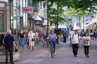 GUETERSLOH, GERMANY - JUNE 24: People stroll in the city center on the Berliner Strasse shopping street during a semi-lockdown following a Covid-19 outbreak at the nearby Toennies meat packaging center on June 24, 2020 in Guetersloh, Germany. Over 1,500 employees of the plant have been confirmed to be infected and authorities have brought in the semi-lockdown, which forces bars, gyms and indoor sports halls to close though allows shops and restaurants to remain open, to stem a further spread of the virus. The Bundeswehr, the German armed forces, has stepped in to help test people at the approximately 250 houses and apartment buildings where Toennies employees, many of whom come from Romania, Bulgaria and Poland, live throughout the Guetersloh region. (Photo by Sean Gallup/Getty Images)