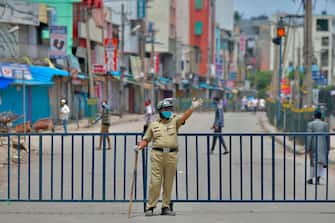 A policeman gestures in front of a barricaded commercial street lined with shops and business establishments, which was closed by the authorities in Bangalore on June 25, 2020 as COVID-19 coronavirus cases continue to rise. - With a population of 1.3 billion, India is the fourth worst-hit country in the world with more than 425,000 infections, official figures show. (Photo by Manjunath Kiran / AFP) (Photo by MANJUNATH KIRAN/AFP via Getty Images)