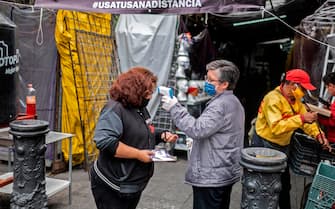 A woman has her temperature checked, within measures to prevent the spread of the new coronavirus, COVID-19, at Iztapalapa market, in Mexico City on June 22, 2020. - The spread of COVID-19 is accelerating across Latin America, with Mexico, Peru and Chile also hard-hit as death tolls soar and healthcare facilities are pushed toward collapse. (Photo by PEDRO PARDO / AFP) (Photo by PEDRO PARDO/AFP via Getty Images)