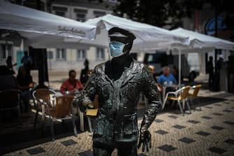 TOPSHOT - A statue wearing a face mask is pictured in downtown Lisbon on June 23, 2020. - Portugal's Prime Minister Antonio Costa said on June 22, 2020 that some coronavirus restrictions would be reimposed in the capital Lisbon to help control outbreaks from the pandemic. According to official data compiled by local media, between May 21 and June 21, Portugal recorded 9,221 new cases of COVID-19 with most cases detected in the Lisbon and Tagus Valley regions. (Photo by PATRICIA DE MELO MOREIRA / AFP) (Photo by PATRICIA DE MELO MOREIRA/AFP via Getty Images)