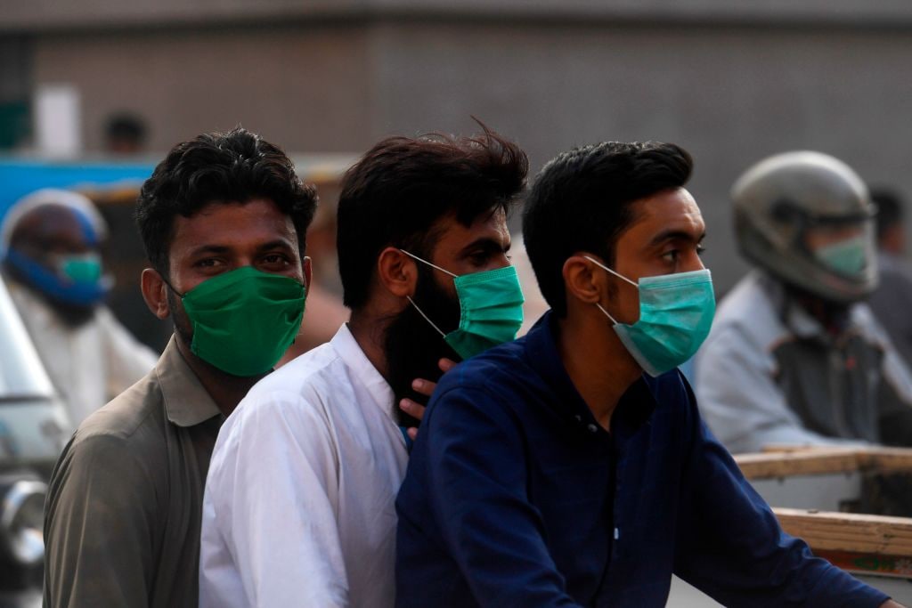 1221922349 Commuters wearing facemasks ride on a bike on a street in Karachi on June 22, 2020 as the COVID-19 coronavirus cases continue to rise. (Photo by Asif HASSAN / AFP) (Photo by ASIF HASSAN/AFP via Getty Images)