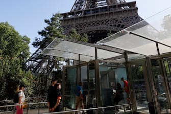 Visitors wearing protective facemasks queue as they wait for the partial reopening of Eiffel Tower on June 25, 2020, in Paris, as France eases lockdown measures taken to curb the spread of the COVID-19 caused by the novel coronavirus. - Tourists and Parisians will again be able to admire the view of the French capital from the Eiffel Tower after a three-month closure due to the coronavirus -- but only if they take the stairs. (Photo by Thomas SAMSON / AFP) (Photo by THOMAS SAMSON/AFP via Getty Images)