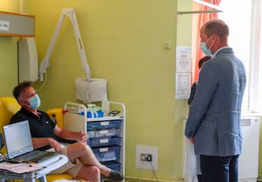 Britain's Prince William, Duke of Cambridge, wearing PPE (personal protective equipment), of a face mask or covering as a precautionary measure against spreading COVID-19, talks to a patient participating in a COVID-19 vaccine trial at Oxford Vaccine Group's facility at Churchill Hospital in Oxford, west of London on June 24, 2020, during a visit to learn more about their work to establish a viable vaccine against coronavirus. (Photo by Steve Parsons / POOL / AFP) (Photo by STEVE PARSONS/POOL/AFP via Getty Images)