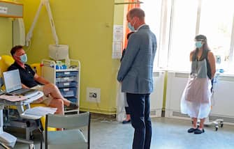 Britain's Prince William, Duke of Cambridge, wearing PPE (personal protective equipment), of a face mask or covering as a precautionary measure against spreading COVID-19, talks to a patient participating in a COVID-19 vaccine trial at Oxford Vaccine Group's facility at Churchill Hospital in Oxford, west of London on June 24, 2020, during a visit to learn more about their work to establish a viable vaccine against coronavirus. (Photo by Steve Parsons / POOL / AFP) (Photo by STEVE PARSONS/POOL/AFP via Getty Images)