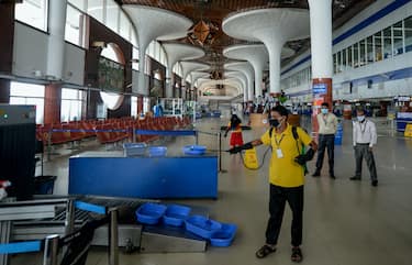 An employee of the Hazrat Shahjalal International Airport sprays disinfectant as a preventive measure against the spread of the COVID-19 coronavirus in Dhaka on June 25, 2020. (Photo by MUNIR UZ ZAMAN / AFP) (Photo by MUNIR UZ ZAMAN/AFP via Getty Images)